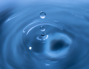 Water drop falling and drips on mirror. Water drop splash and make perfect circles on water surface.