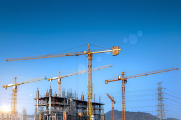 Workers are working on large construction sites and many cranes are working in the construction industry.