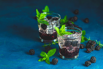 Cold summer berry drink with blackberries. Refreshing summer drink with syrup, blackberry and ice...