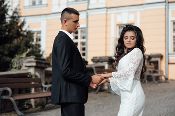 Beautiful and happy woman and man pose holding hands. Romantic man and woman in love. Love story. Beautiful couple in love. Girl in the dress and the guy in the suit.