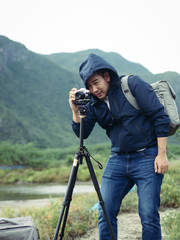 Asian photographer taking photo with tripod in winter season, lifetyle concept.