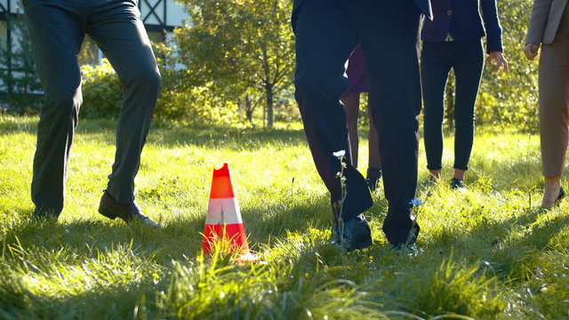 Man in suit goes through obstacle course in courtyard.