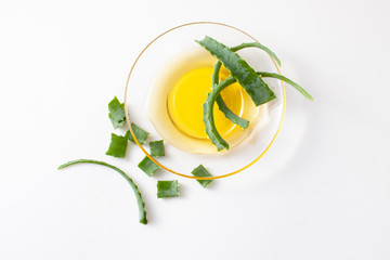 Aloe Vera leaves and fresh honey in bowl on white background