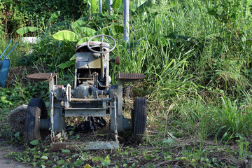 Wasted dilapidated rustic old farm tractor left on the vicinity of agricultural college campus