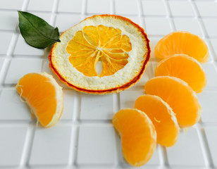 Slices of mandarin lie on a white heterogeneous surface. Tangerine slices close-up.