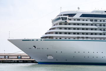 Fototapeta na wymiar White cruise ship moored at berth in the sea