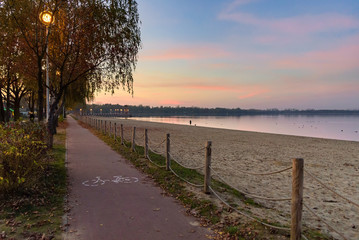 Bicycle path at Pogoria III lake at sunset