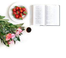 Naklejka na ściany i meble Bible flat lay with pink flower bouquet, strawberries, coffee and a Bible on white background. Space for text.