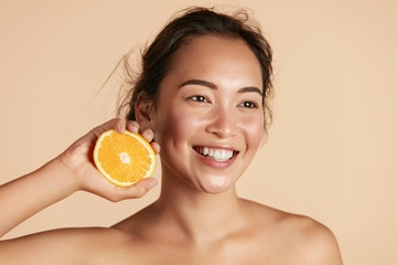 Beauty. Smiling woman with radiant face skin and orange portrait. Beautiful smiling asian girl...