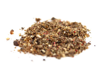 A mix of four types of ground pepper: black, white, pink, green. Isolated on white background....