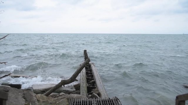 Waves Crash in on Abandoned Warf Along Shoreline 25fps