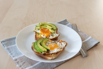 Toast with avocado and fried egg. Healthy breakfast.