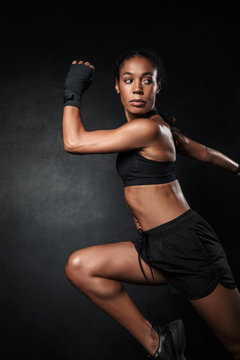 Image of african american woman in sportswear and hand wraps running