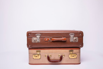 Old, retro, suitcases lie on the table with white background