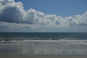 seashore reflection on the shore and bright cloudy sky