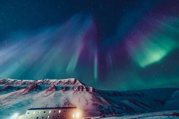 Zelfklevend Fotobehang Het polaire arctische noorderlicht jaagt op aurora borealis sky star in Noorwegen reisfotograaf Svalbard in Longyearbyen city the moon mountains © bublik_polina