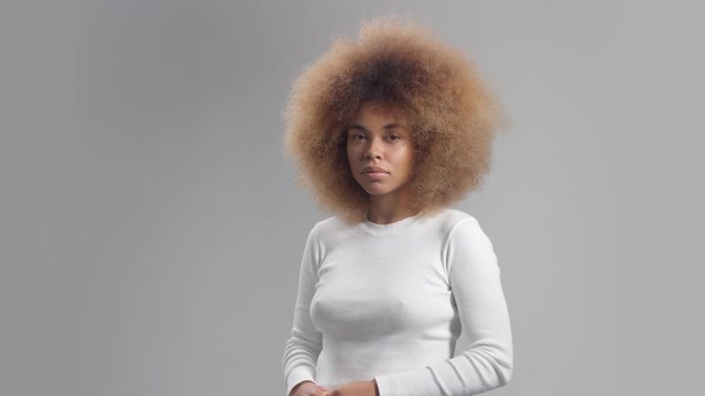 Mixed race black woman with big afro hair panned portrait