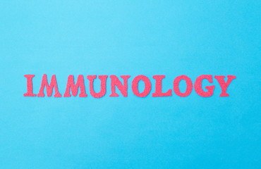 The word immunology in red letters on a blue background. The concept of the section of medicine dealing with the study of human immunity