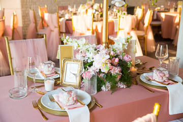 Beautiful dinner table decorated by gold accessories and flowers. Wedding. Decor