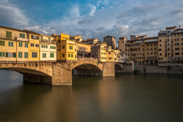 Fototapeta na wymiar Side view of medieval stone bridge Ponte Vecchio over the Arno River in Florence, Tuscany, Italy.