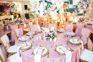 Beautiful dinner table decorated by gold accessories and flowers. Wedding. Decor