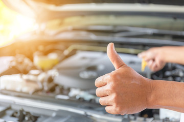 Close up of Technician man giving thumb up after checking engine oil level, Car repair and...