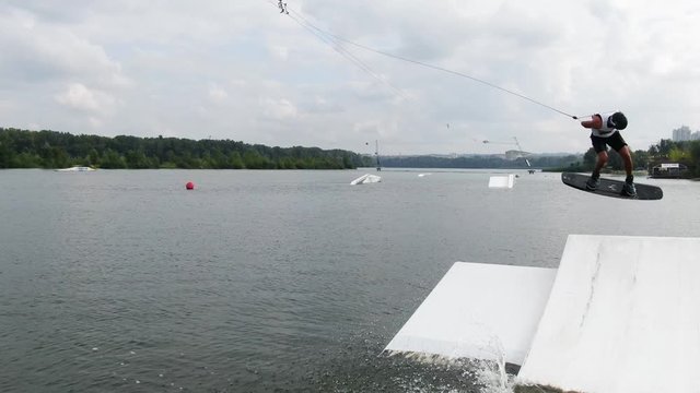 Wakeboarder is doing lots of back rolls while in the air, slow motion