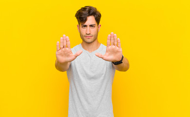  looking serious, unhappy, angry and displeased forbidding entry or saying stop with both open palms