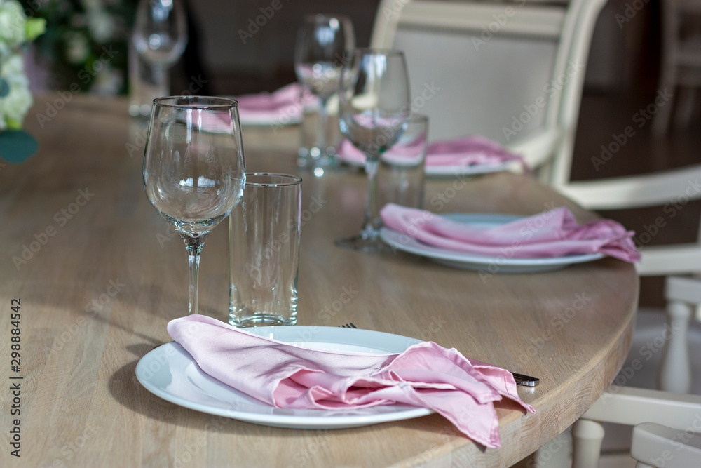 Wall mural white plates with pink napkins on a wooden table