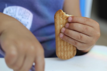 Criança segurando biscoito de maizena