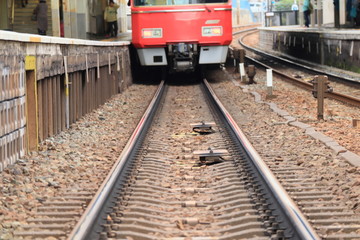 Naklejka premium 線路と駅で停まる赤い電車