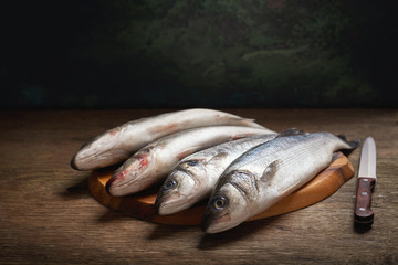 fresh fish are ready for cooking on a wooden table
