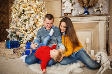 Merry Christmas and Happy New Year concept. Happy family celebrating winter holidays at home near christmas tree