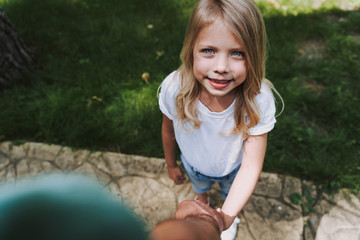 Adorable little girl holding hand of her father