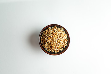  wheat sprouts in a blue ceramic bowl on a white background. good nutrition concept