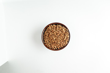 Buckwheat grains in a bowl on a white background isolate