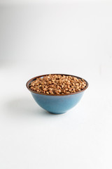 Buckwheat grains in a bowl on a white background isolate