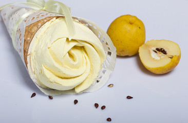 Waffle cone filled with quince marshmallows. Decorated for a gift. Nearby are the fruits of quince.