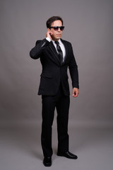 Obraz na płótnie Canvas Full body shot of handsome Persian businessman with sunglasses