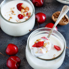 Fermented yogurt kefir in small bottles with cherries and walnuts