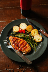 Steak with fried potatoes and green beans in a white plate