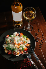 Fresh caesar salad in white plate on dark wooden table. Top view copy space.