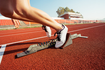 Detailed view of a female sprinter in the starting blocks