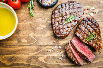 Grilled marbled meat steak Filet Mignon with seasonings. Juicy beef steak on cutting board, top view.