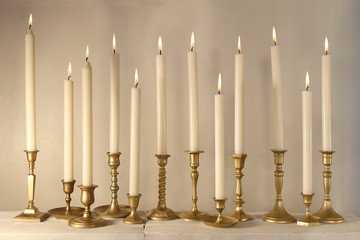 Burning candles in retro candlesticks indoor.  .