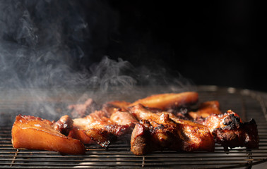 BBQ Grilled pork on the grill with smoke and steam rise from a pork steak