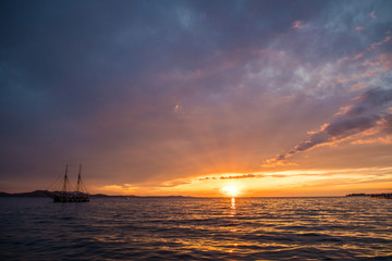 Naklejka na ściany i meble Zadar, Croatia - July, 2019: Old seaboat over Sunset in Zadar, Croatia