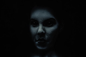 Scary and frightening  demonic woman face with black eyes in the dark.  Diabolic  and possessed by...