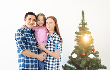 Holidays, gifts and christmas tree concept - Small family having happy time together on Christmas.