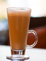 Vertical shot of Glass cup latte with bokeh effect